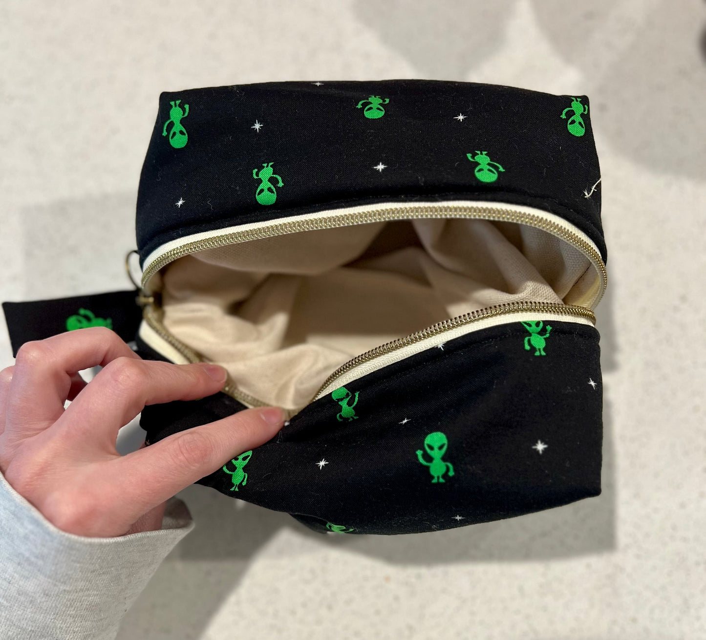Handmade alien pouch with zipper closure, ideal for makeup or art supplies storage.