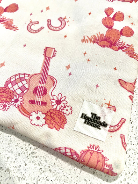 Pink cowgirl themed small book sleeve with quilted cotton design and zipper.
