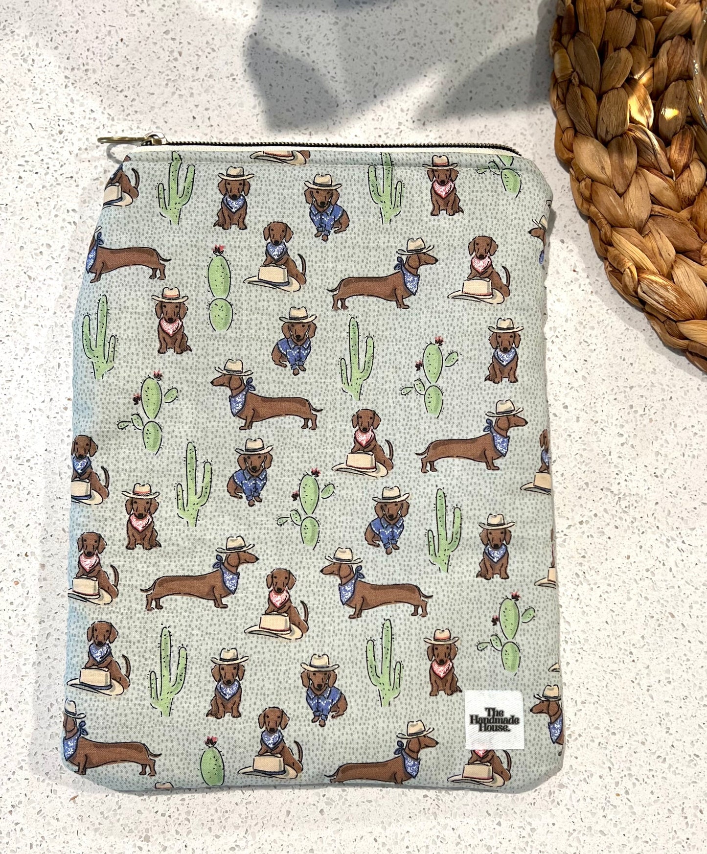 Dachshund small book sleeve with quilted cotton fabric and zipper, featuring cowboy-themed dachshund print.