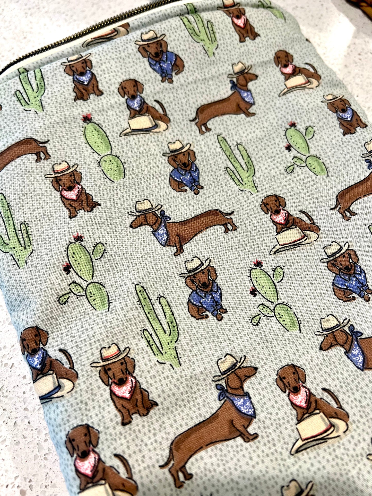 Dachshund-themed quilted book sleeve with zipper, cotton fabric, and cactus design.
