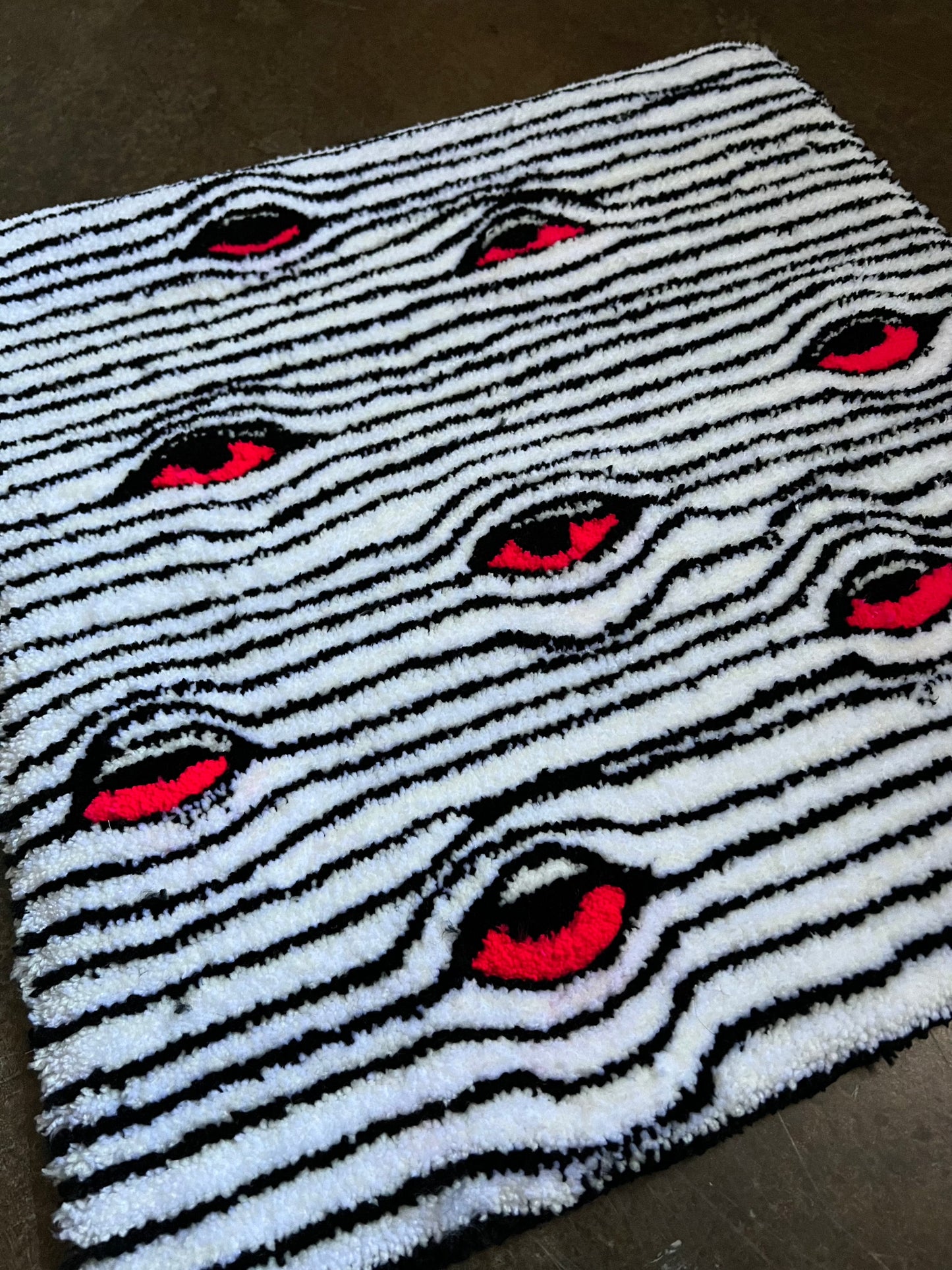 Eyes Rug with black and white stripes featuring red eye pattern.