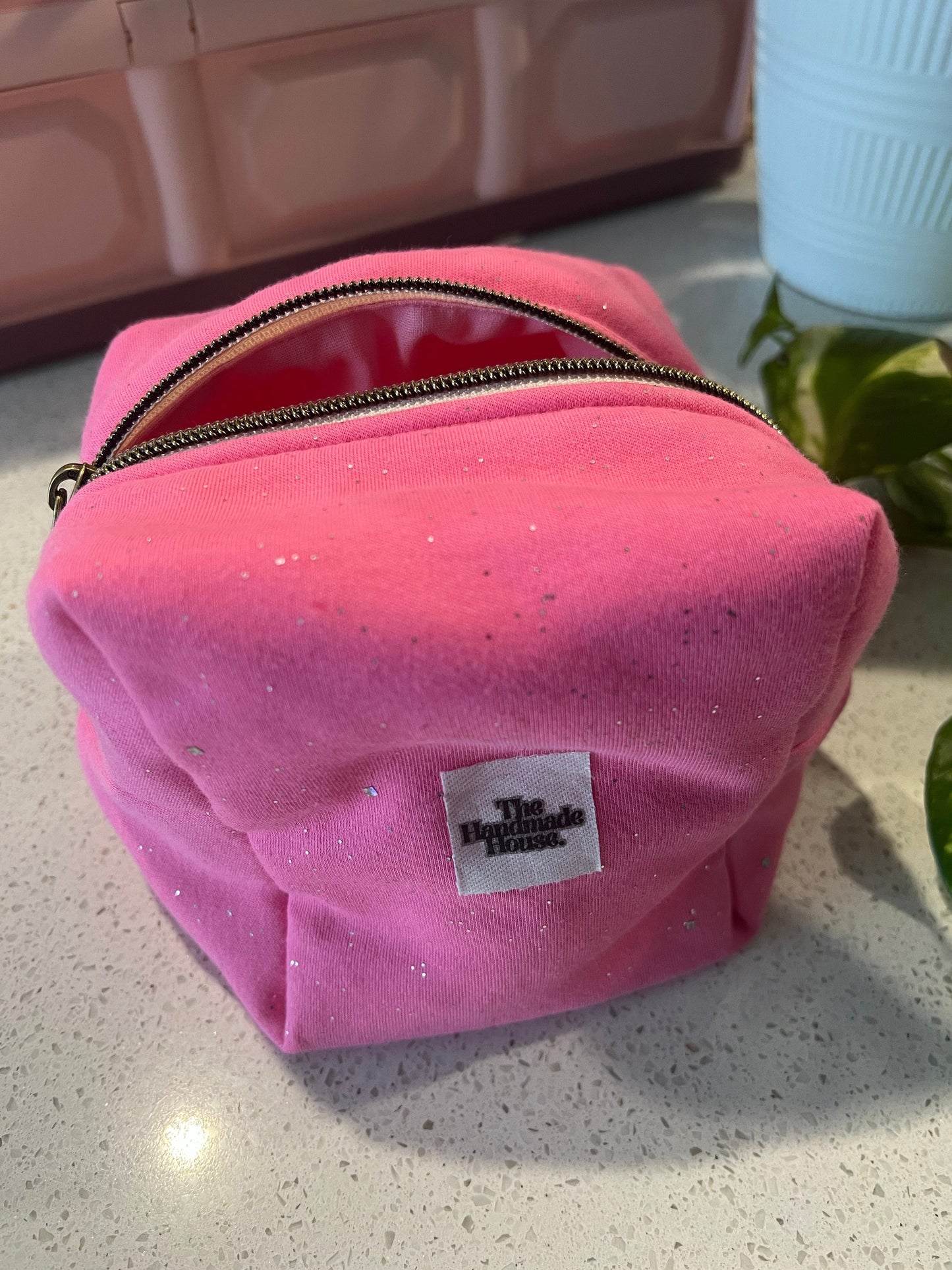 Handmade pink pouch with zipper closure, perfect for makeup or art supplies.