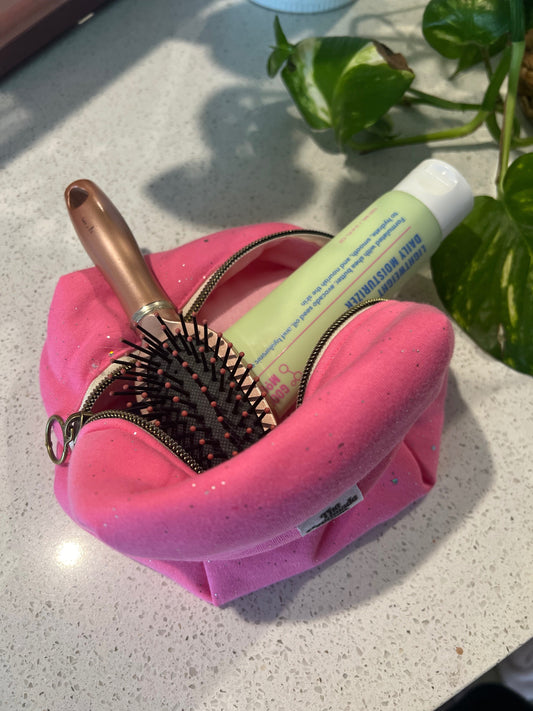 Handmade pink pouch with zipper closure, shown holding makeup and art supplies.