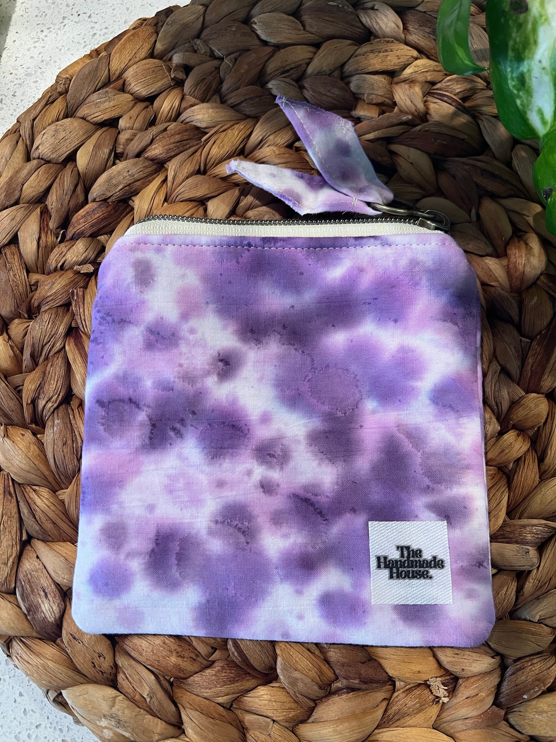 Purple Mini Pouch made of handmade cotton on woven mat surface.