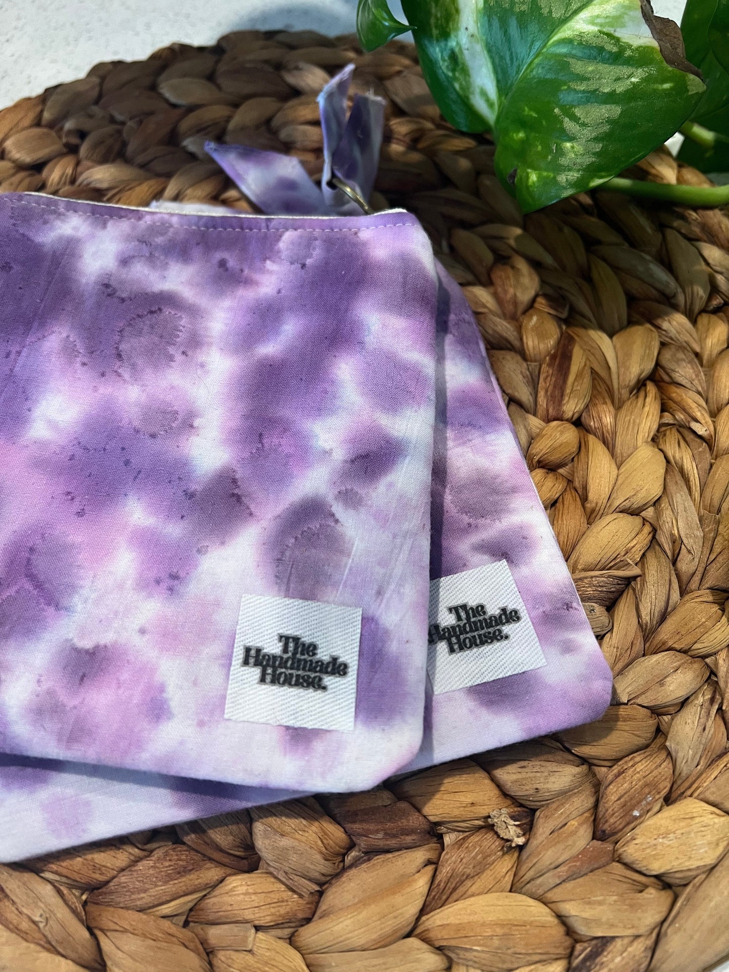Purple mini cotton pouch on woven mat surface.