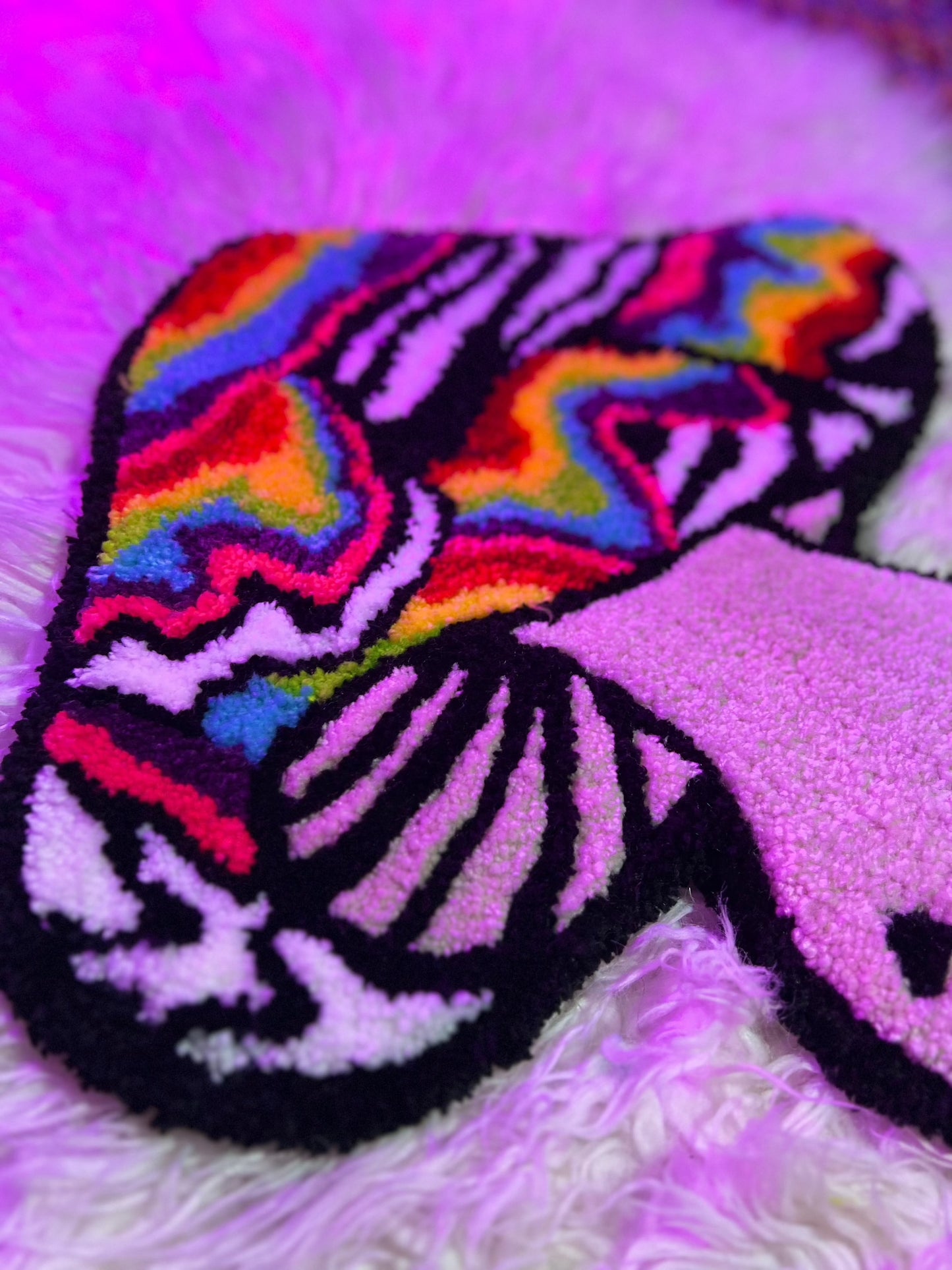 Colorful psychedelic mushroom rug labeled "Drop 2" on fluffy surface.