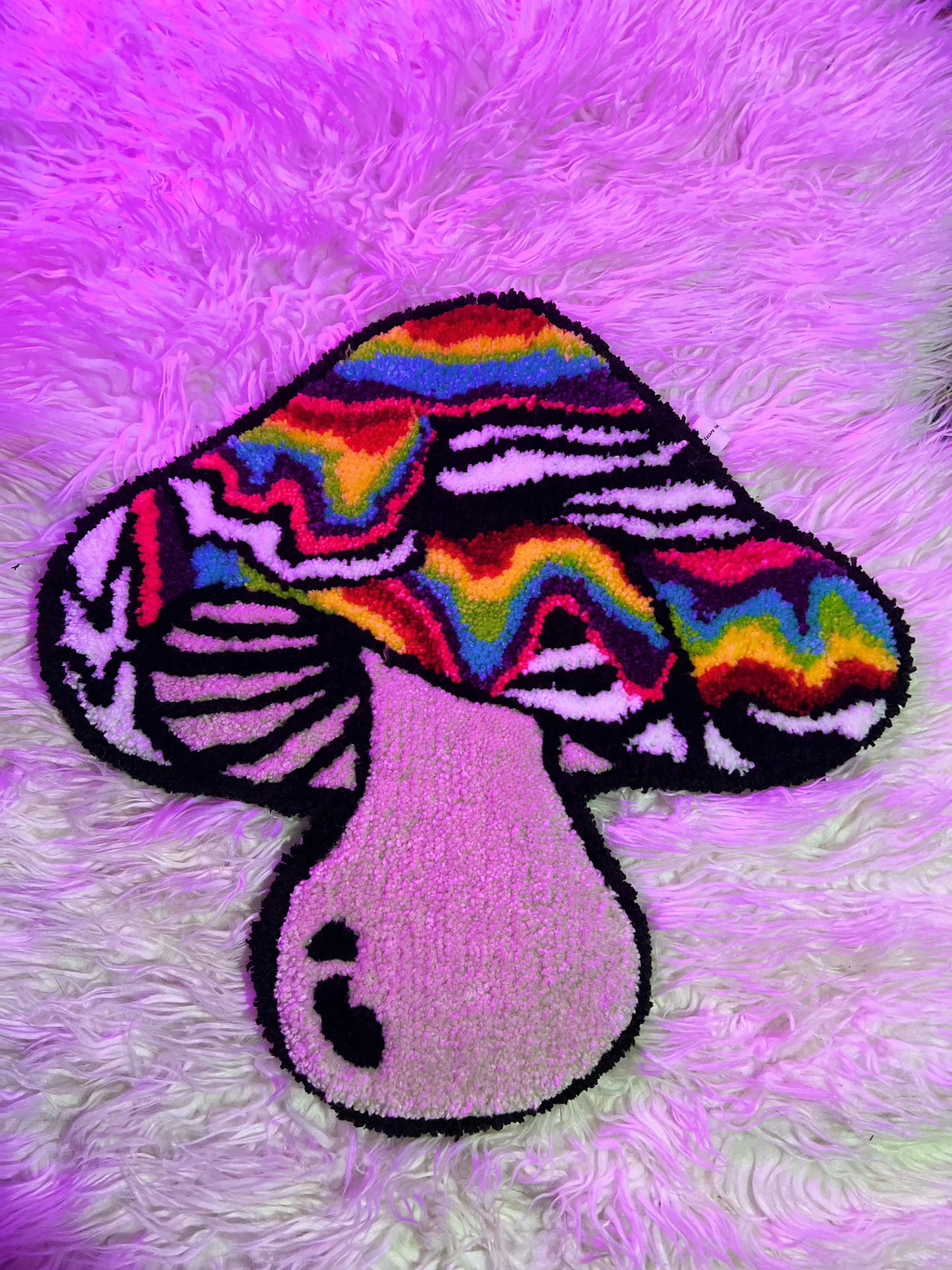 Tufted psychedelic mushroom rug with vibrant colors on fluffy background.