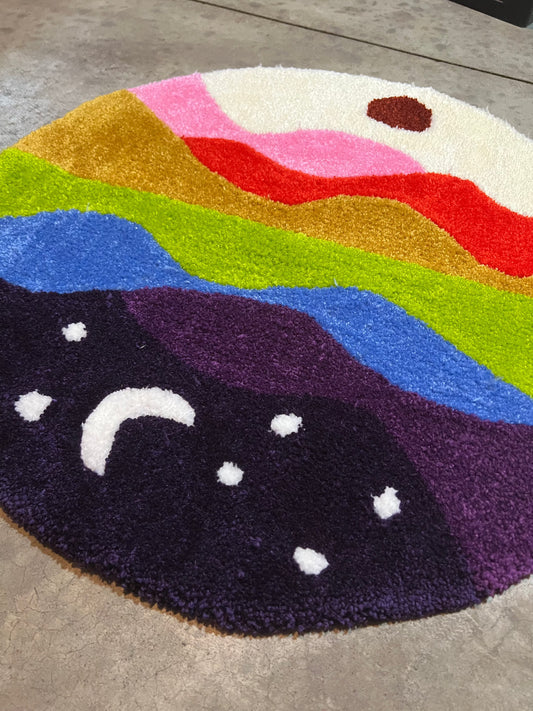 Colorful circular rug depicting a stylized skyline; size 27x27 inches; focus keyword: Drop 3.