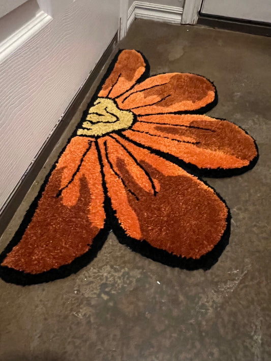 Sunflower-shaped rug in bold orange and yellow tones, size 32x17, Drop 3 collection.