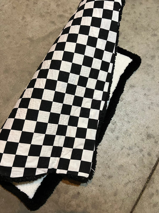 Checkered design blanket, Drop 3, size 22x21 inches on concrete floor.
