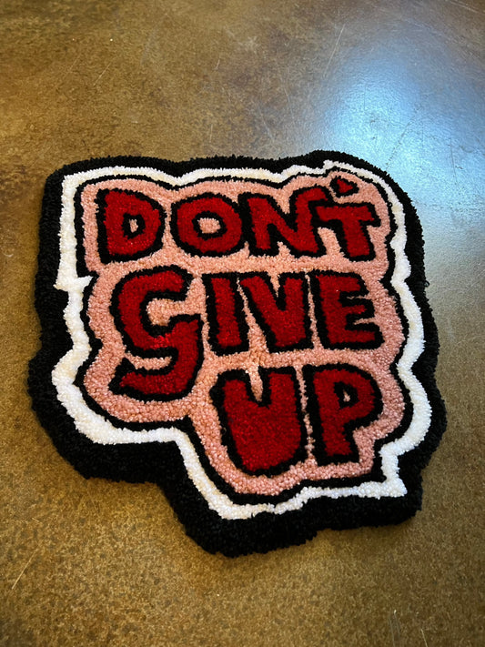 Motivational rug with "Don't Give Up" text, 16x15 inches, vibrant colors, Drop 3 design.