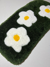 Flower garden computer mat with white and yellow flower design on green background.