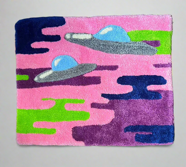 Colorful UFO-themed rug with vibrant designs on a pink background.