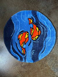 Round rug with vibrant orange koi fish on a blue background.