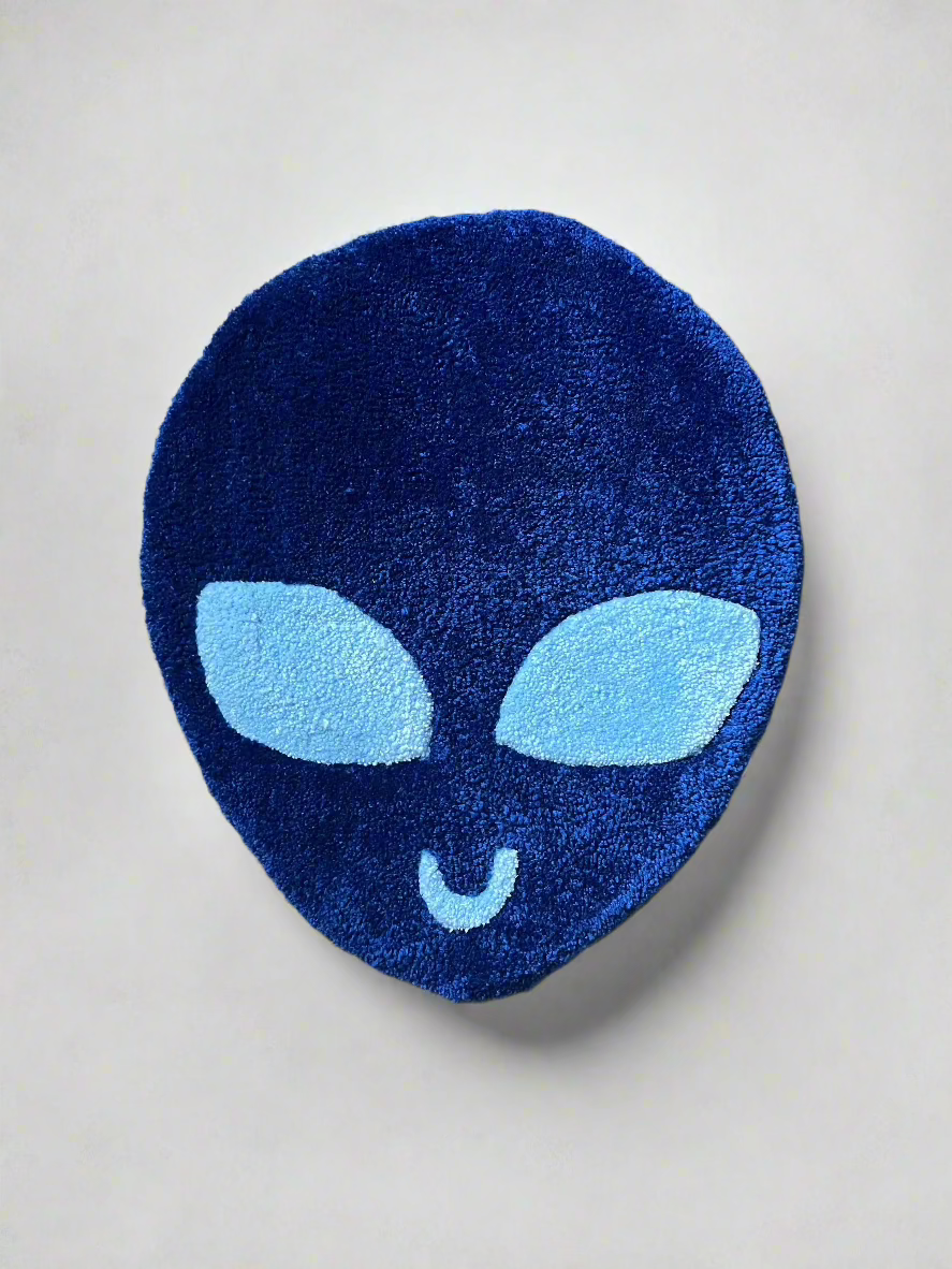 Blue alien rug with distinct design on textured floor.