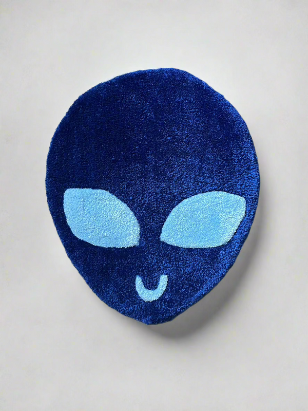 Blue alien rug with distinct design on textured floor.