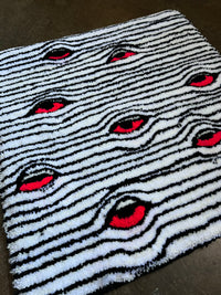 Eyes Rug with black and white stripes featuring red eye pattern.