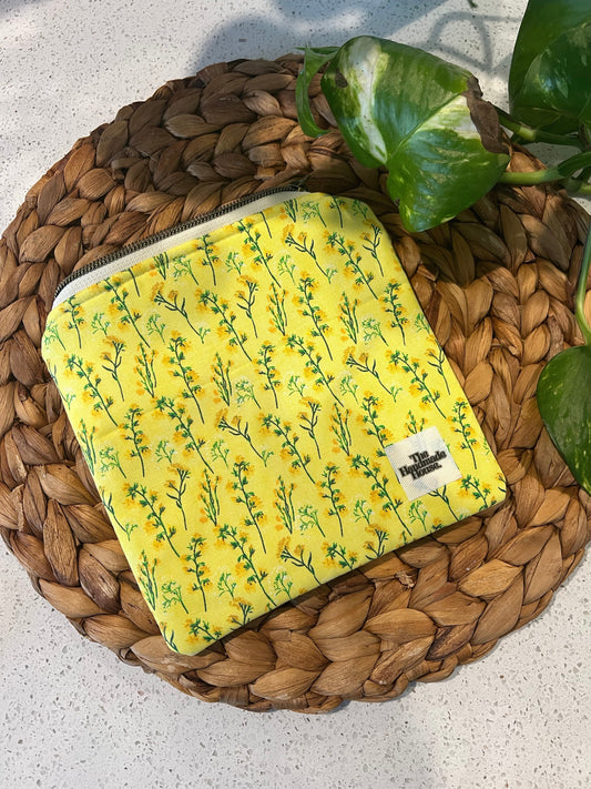 Handmade yellow flower mini pouch on woven mat.