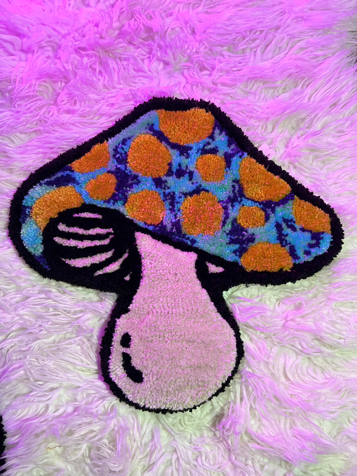 Colorful blue and orange mushroom rug on purple background, part of Drop 2 collection.