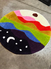 Round colorful rug titled 'Drop 3: Skyline', size 27x27, featuring vibrant abstract landscape design.