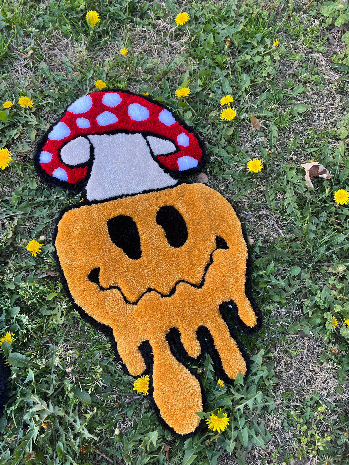 Mushroom Smiley rug, 23x12 inches, drop 2 design on grass.