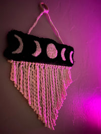 Wall hanging with moon phases design, size 21x13 inches.